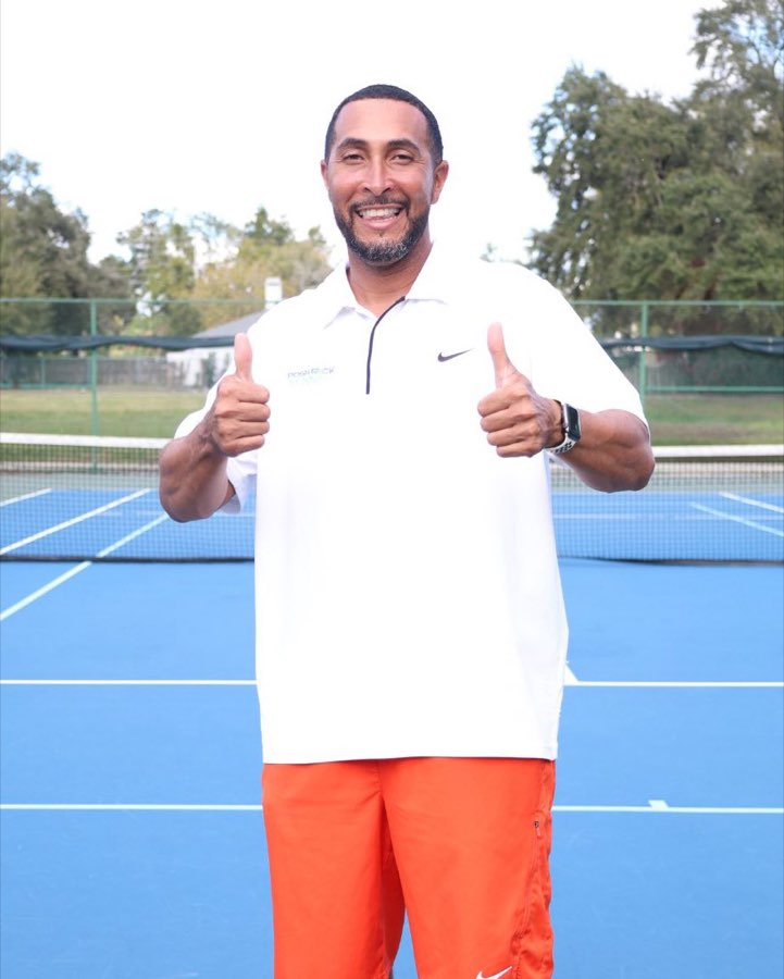Coach Albert Richards smiling with two thumbs up on court